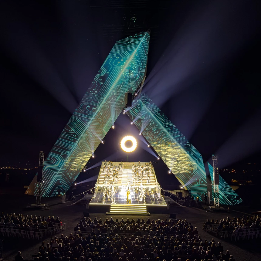 Projection mapping with futuristic content on the sculpture Saarpolygon creates an atmospheric backdrop for the opera Magic Flute