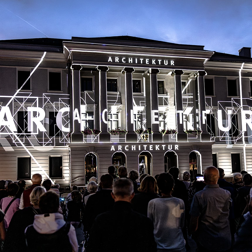 Die Details der Fassade werden mit abstrakten Linien nachgezogen, während sich das Wort "Architektur" über seine gesamte Breite erstreckt