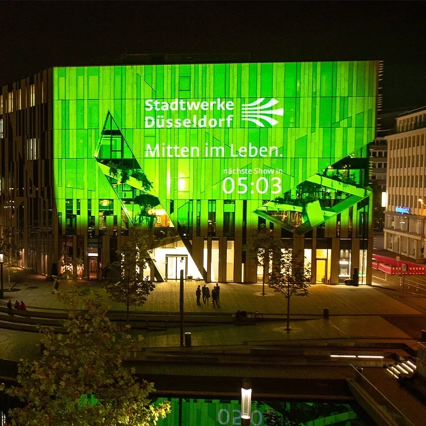 Projection mapping projection with the logo of Stadtwerke Düsseldorf at the Kö-Bogen