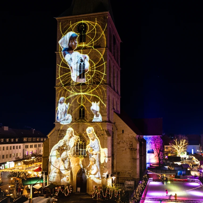 Fassadenindividuelle Video-Projektion auf Kirchturm in Hamm zeigt christliche Krippenfiguren
