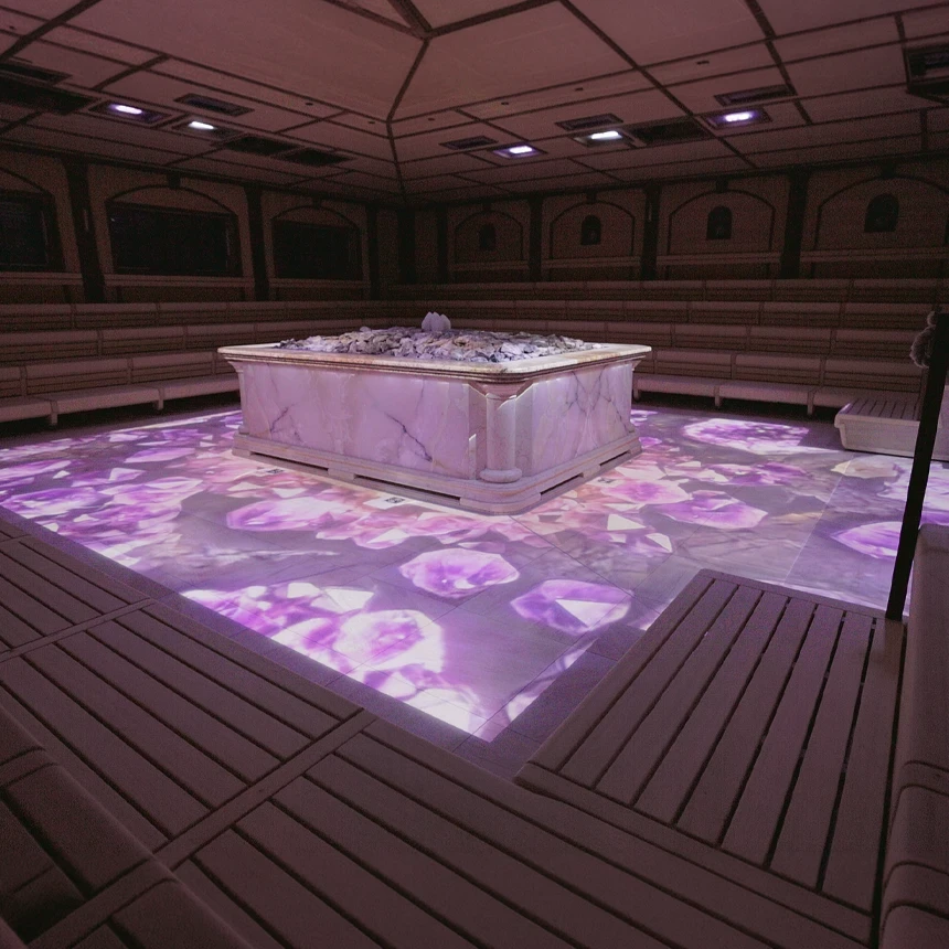 Immersive projections stage the Crystal Palace in keeping with the corporate design: violet gemstone motifs cover the sauna floor and the marble sauna heater—large-scale projections, lighting, and music create a holistic experience, brought to you by TNL GmbH.