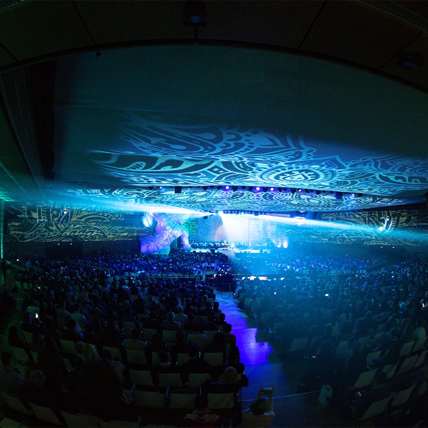 Projektion in einer Kongresshalle mit 3D-Videomapping, welche verschiedene Muster und Farben zeigt