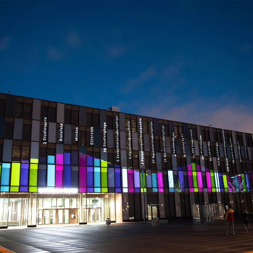 3D Video Mapping auf Hochschulfassade als Infotainment zeigt Schriften und Balkendiagramm