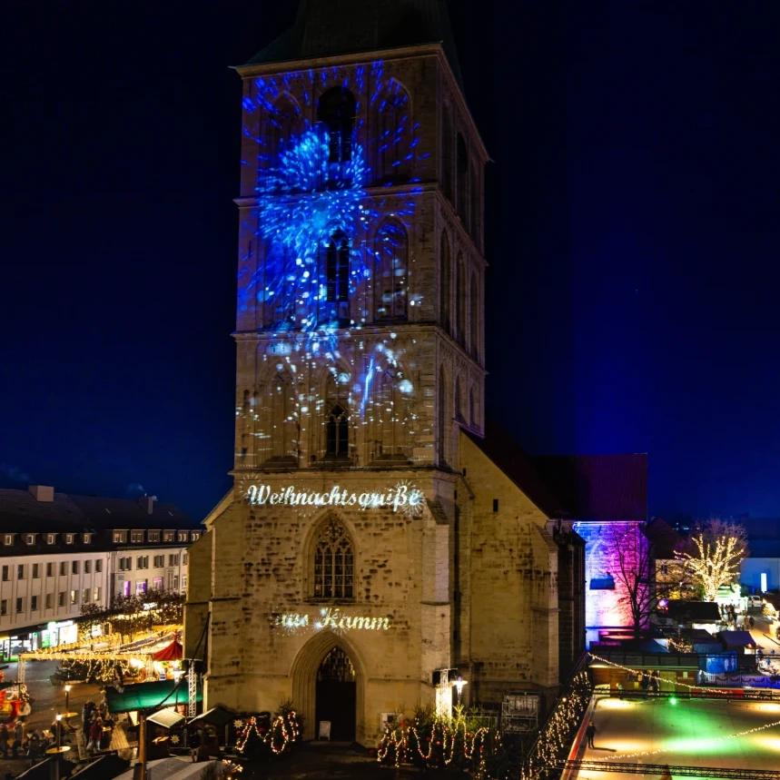 Virtuelles Feuerwerk und Weihnachtsgrüße sind auf der Fassade der Pauluskirche in Hamm großflächig und effektvoll per Videoprojektion zu sehen