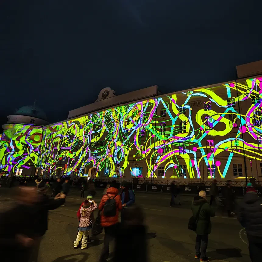 Bei einem 3D Video Mapping werden bunte Formen und Linien auf die Fassade der Hofburg und-kirche projiziert und bewegen sich dynamisch