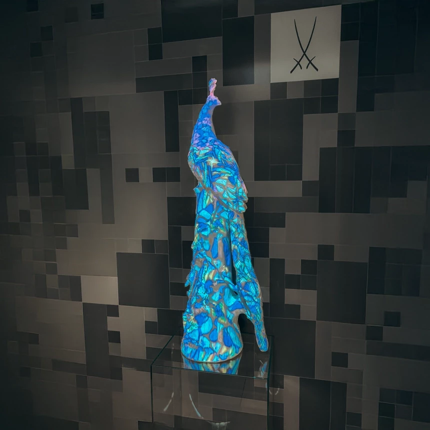 Groß-Skulptur eines Pfaus aus Porzellan bekommt ein virtuelles buntes Federkleid als Projektion durch 3D-Videomapping