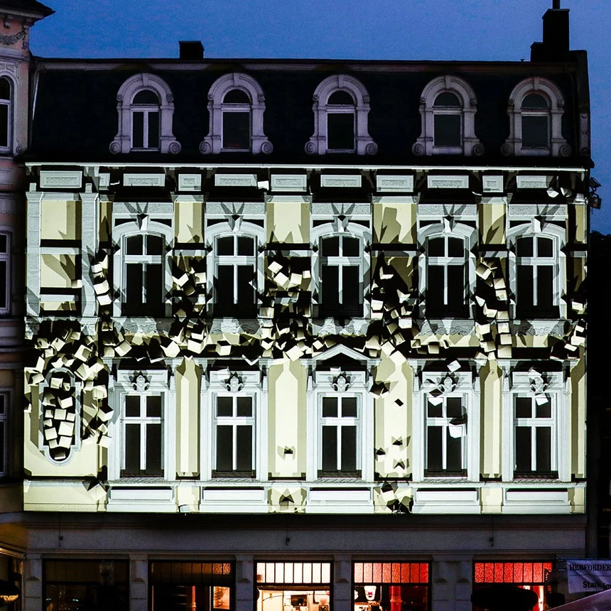 Augmented Reality Videoprojektion mit animierten Würfeln erweckt den Eindruck, die historische Fassade sei in Bewegung