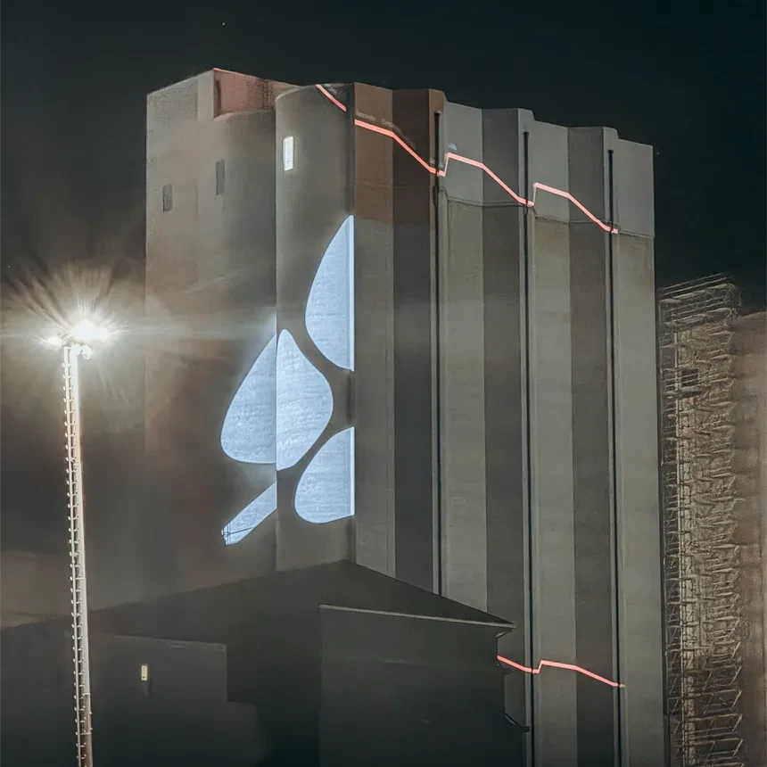 A facade painting across the corner of a grain silo was implemented using a stencil projection: one facade projection was used on each side of the building, which in the overall image represented an ear of grain on the building.