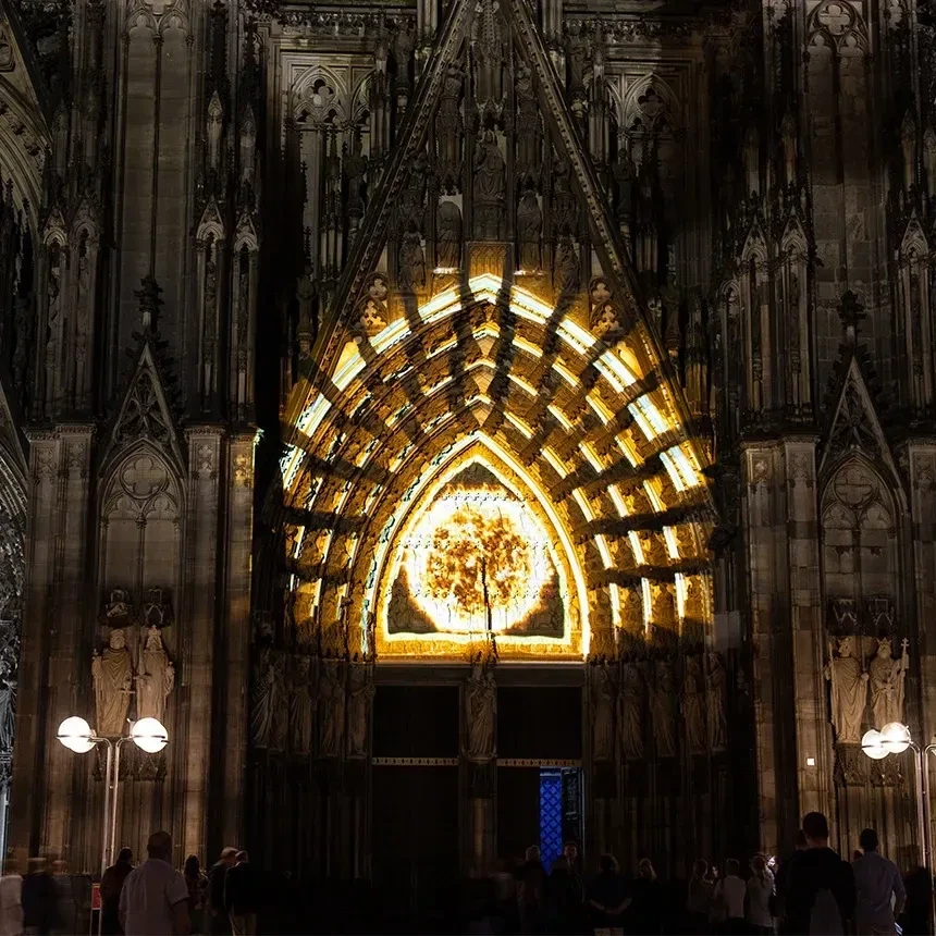 Projection onto the west portal of Cologne Cathedral with a golden fireball