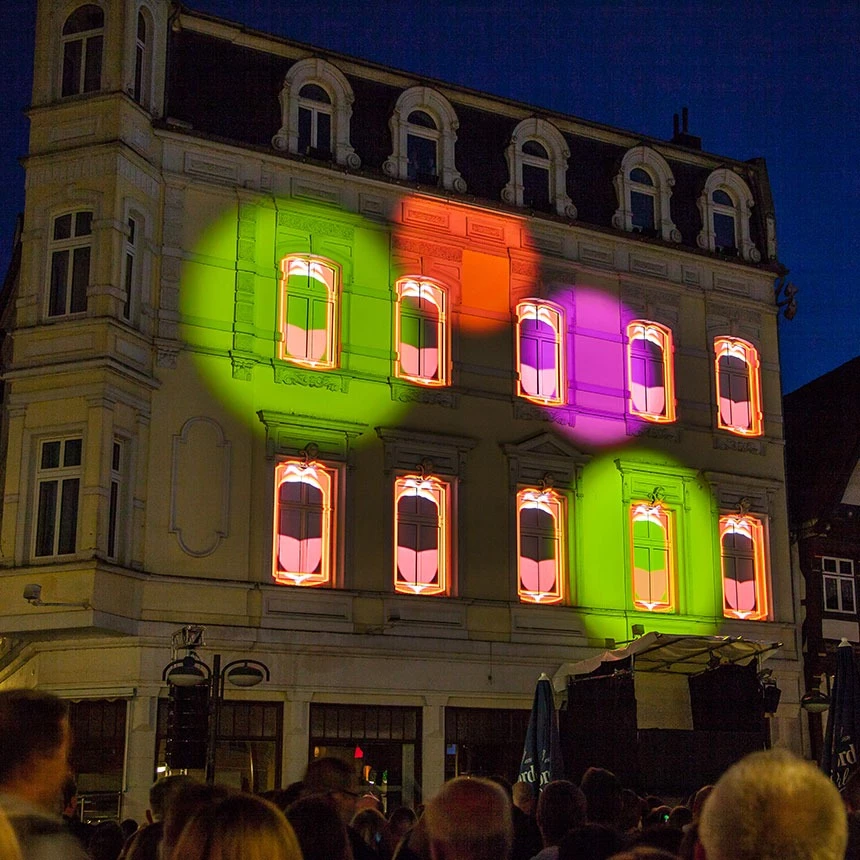 Fassadenprojektion mit gebäudeindividuellen Effekten auf der Fashion Plaza beim Stadtfest in Herford zeigt farbige Spots und Münder im Stil von Pink Floyd