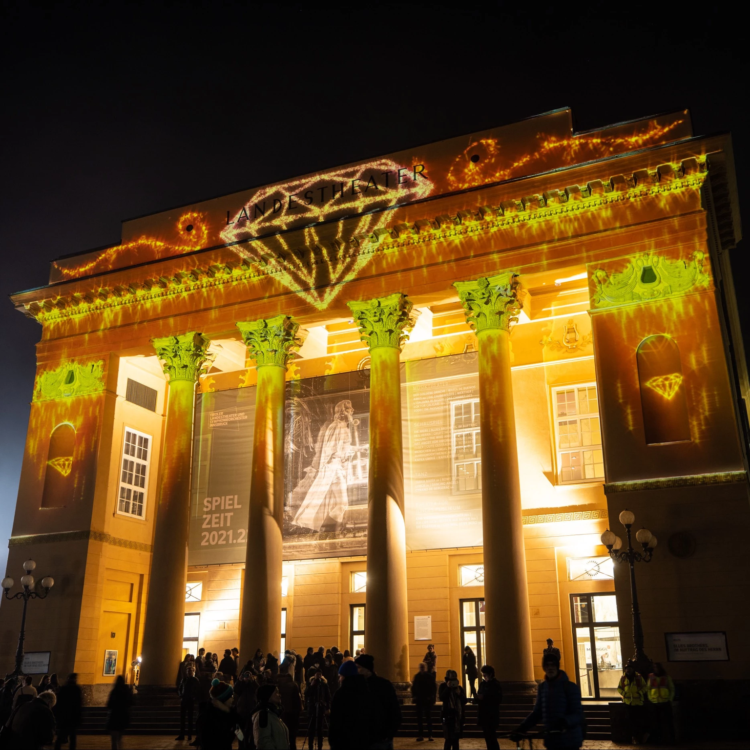 Das Landestheater in Innsbruck mit 3D Videoprojektionen inszeniert: animierte Goldpartikel und Diamanten sind auf der Fassade zu sehen