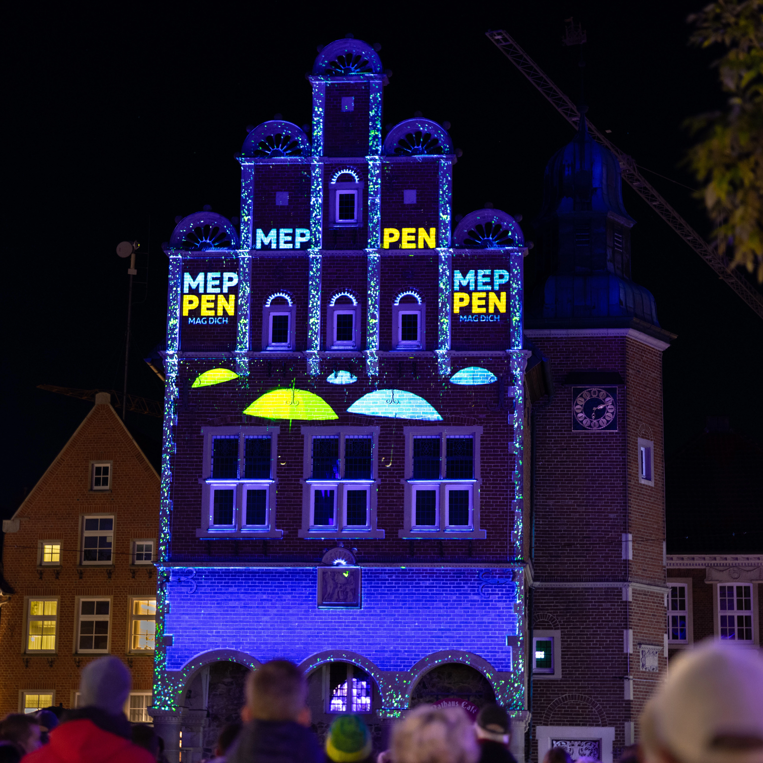 Vom Stadtmarketing initiierte Lichtshow zeigt Regenschirme und Logo in den Farben der Stadt Meppen