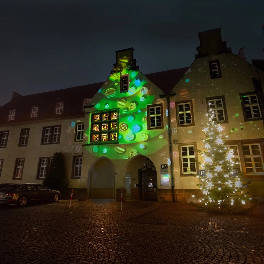 3D Fassadenprojektion eines Weihnachtsbaums auf die historische Rathausfassade von Halle Westfalen zur Adventszeit