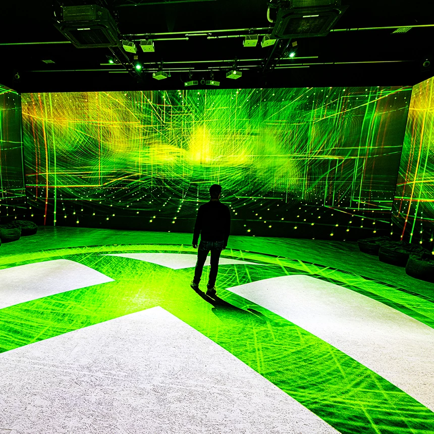 Bei einer multimedialen Installation werden auf die Wände abstrakte Linien projiziert, während der Boden mit dem Xbox-Logo geschmückt wird