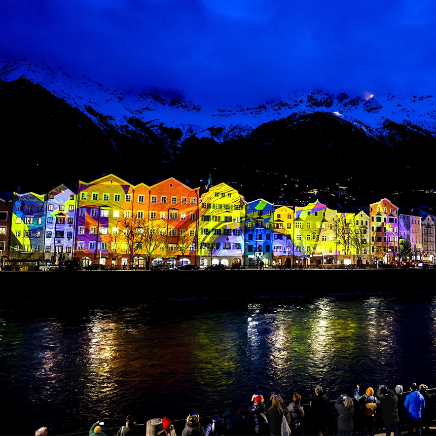 The skyline of Mariahilfstrasse in Innsbruck is illuminated with colorful abstract 3D video mapping