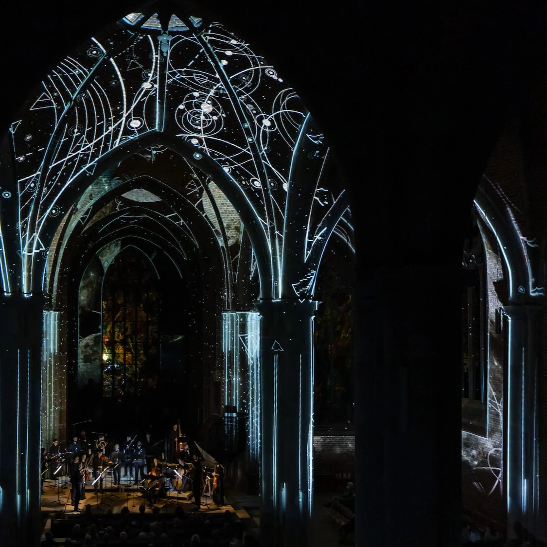 Linien und geometrische Formen als Videoprojektionen auf Kirchengewölbe während eines Konzerts