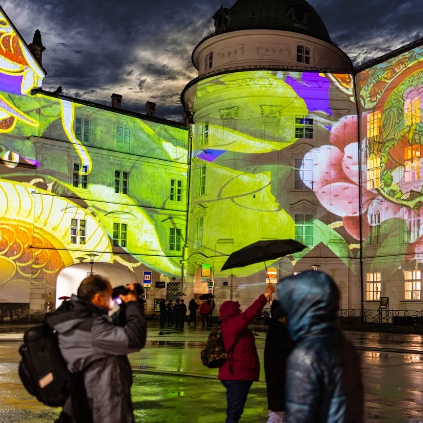 The Hofburg Innsbruck is illuminated with abstract, colorful graphics and flowers during a projector show
