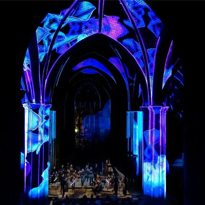 Interior of a church with a 3D video mapping immersively staged with a cool play of colors