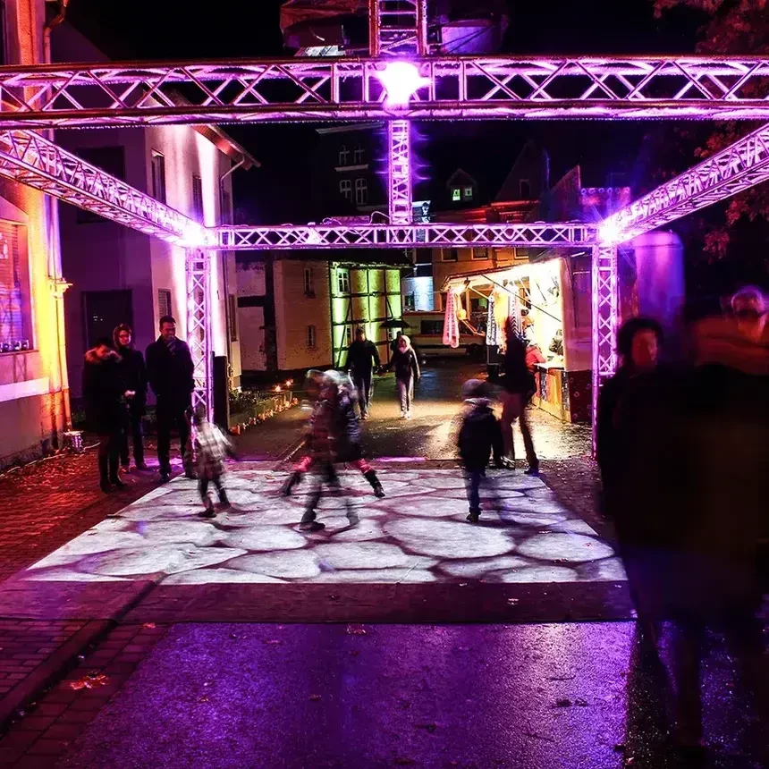 Kinder spielen auf einer interaktiven Bodenprojektion in der Innenstadt von Steinheim