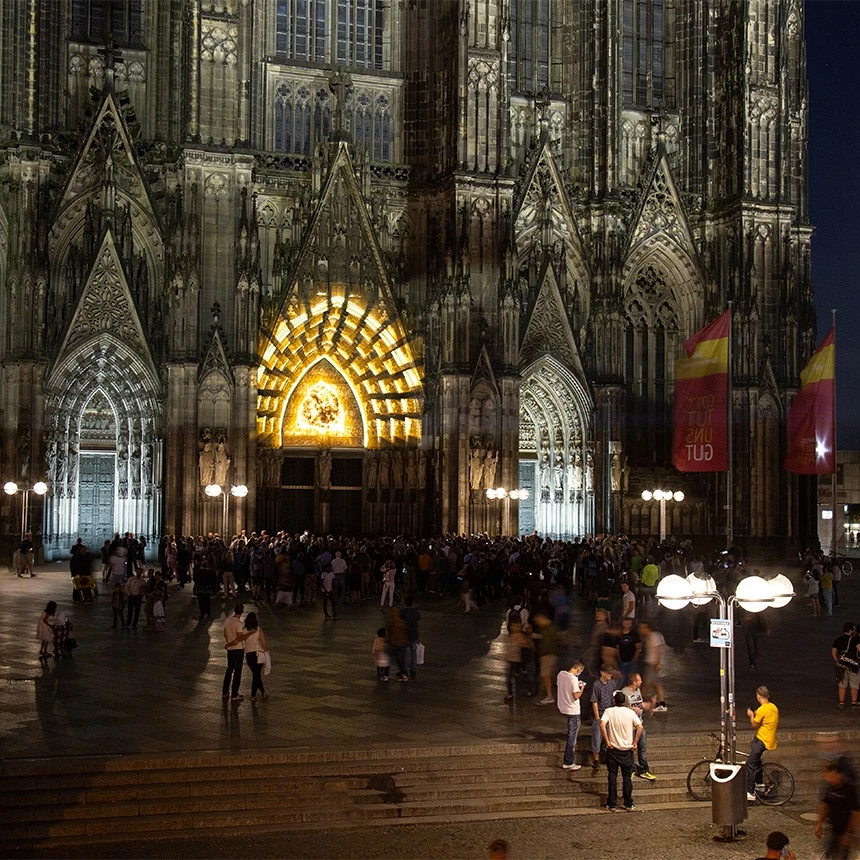 Videoshow als atmosphärische Lichtkunstinstallation in gold am Domportal in Köln