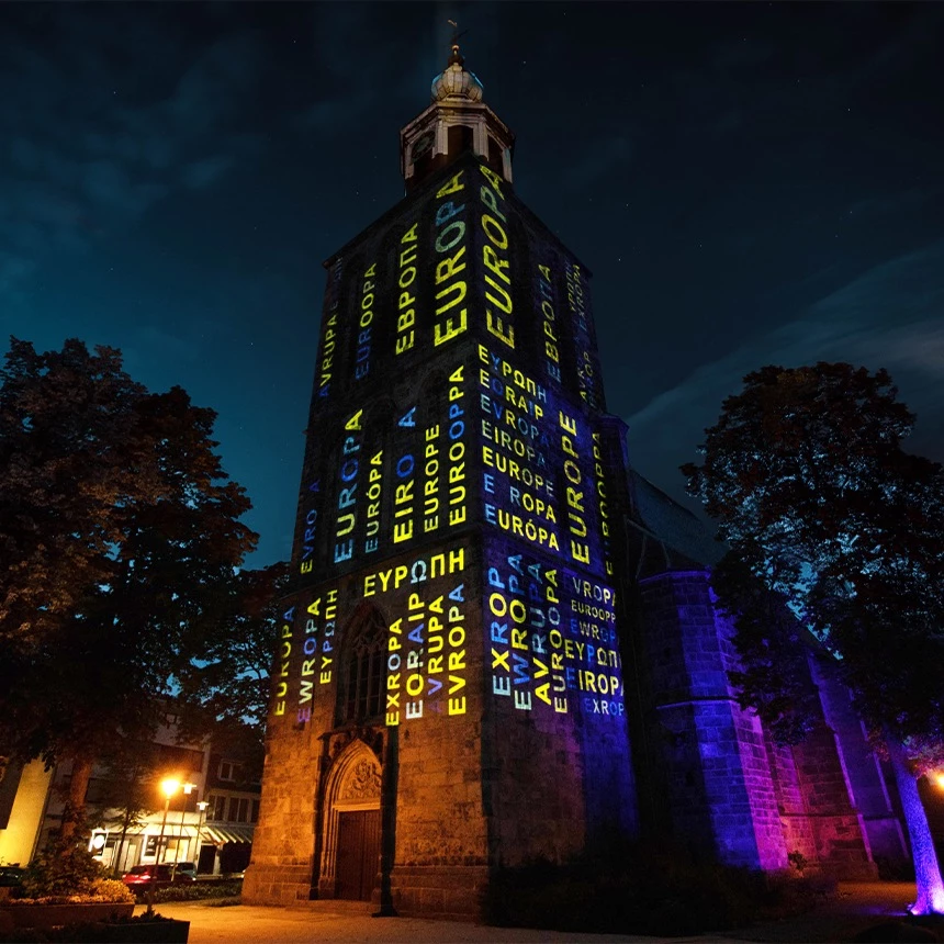 Building-specific projection on church tower with word grid on the subject of Europe