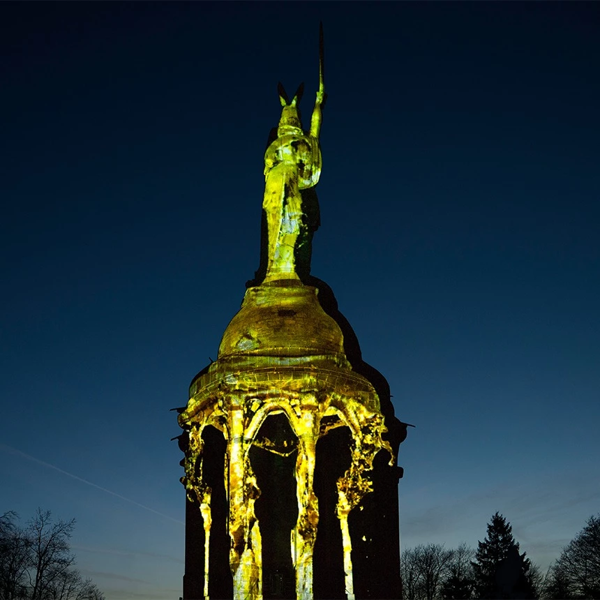 During an illumination, the Hermann monument is covered with virtual liquid gold, which flows down the pillars in the lower part of the building