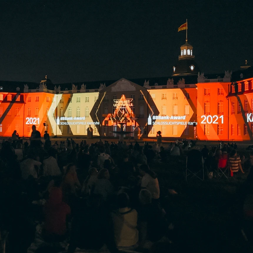3D-Projectionmapping auf dem Karlsruher Schloss bei den Schlosslichtspiele 2023 – TNL GmbH bespielt die barocke Schlossfassade mit dynamischen Lichtgrafiken in Orange und Rot vor tausenden Zuschauern