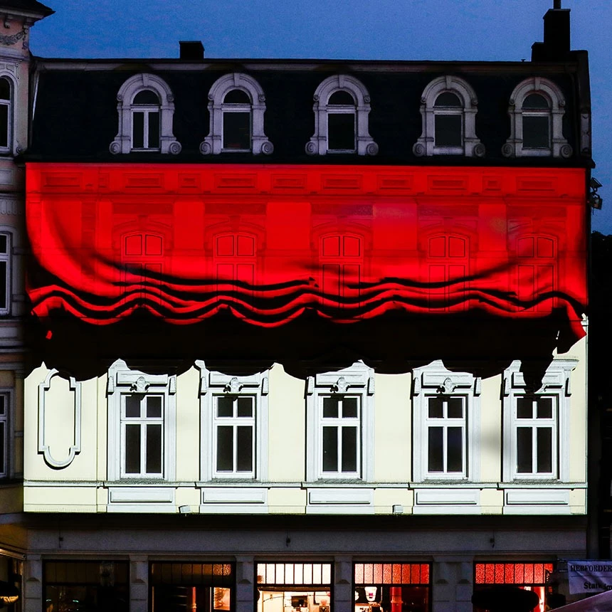 Zum Beginn der 3D Video Mapping Show wird virtuell ein roter Vorhang an der Fassade am Alten Markt gelüftet