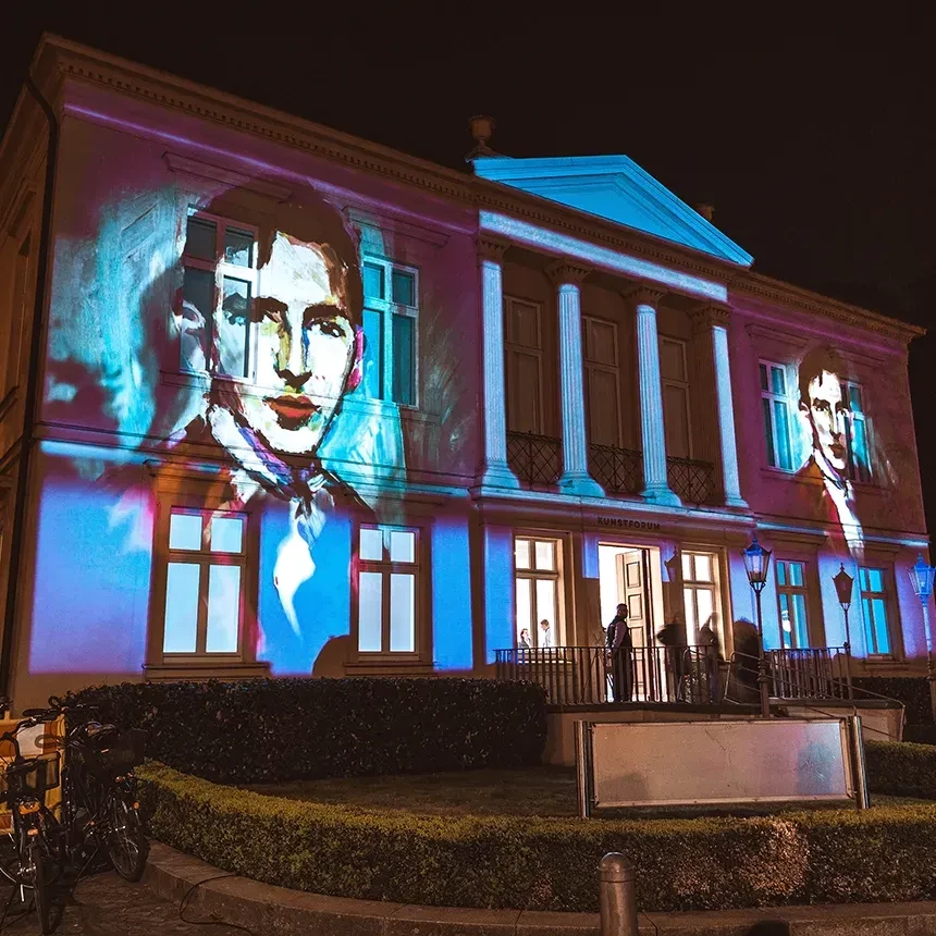 Auf das Gebäude wird ein Gemälde der Ausstellung gebäudeindividuell in Szene gesetzt