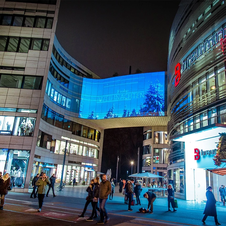 3D video mapping on a modern building greets visitors to the Kö-Bogen shopping center with the message Merry Christmas
