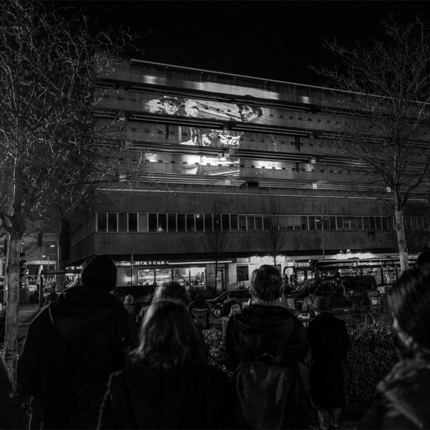 Fassadenprojektion an einem zentralen innerstädtischen Gebäude zum Gedenken der Judenverfolgung zeigt Archivbilder.