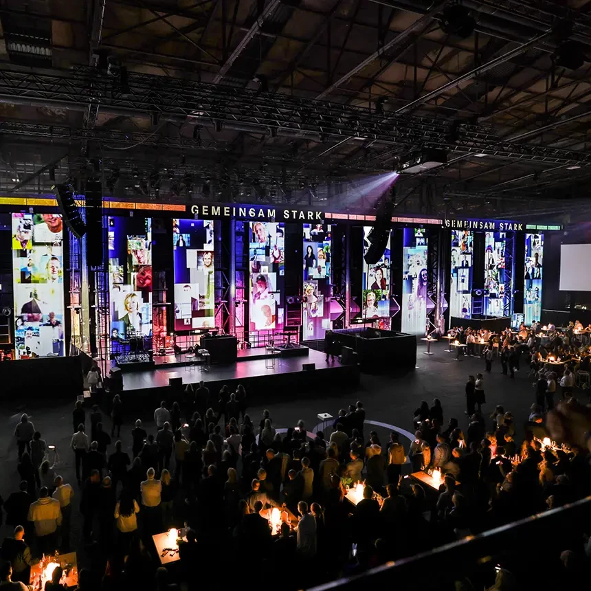 During an evening event, the audience looks at a projection show starring photos of various employees at your company