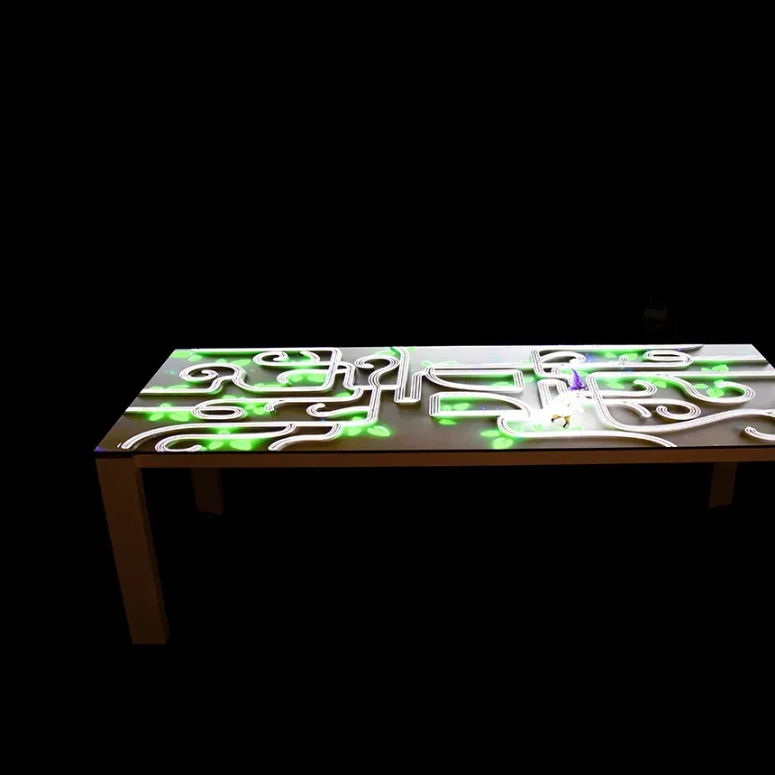 Videoprojektion auf Tisch im Showroom zeigt grüne Blätter und weiße Linien angestrahlt