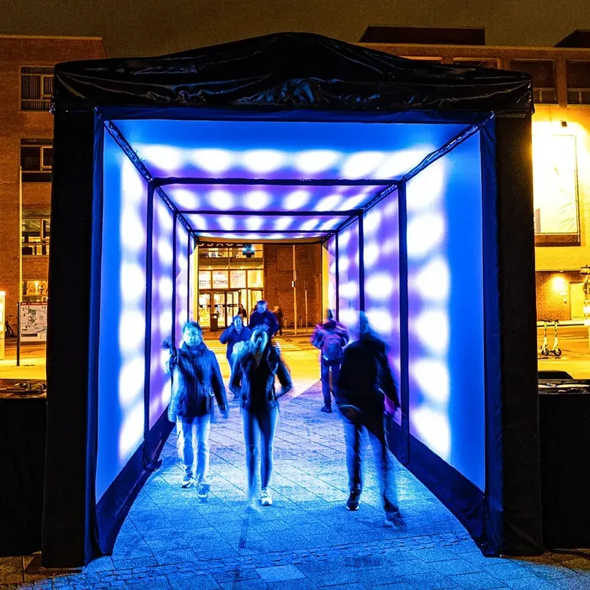 Menschen gehen durch einen blau scheinenden Lichttunnel in der Wilhelmshavener Innenstadt