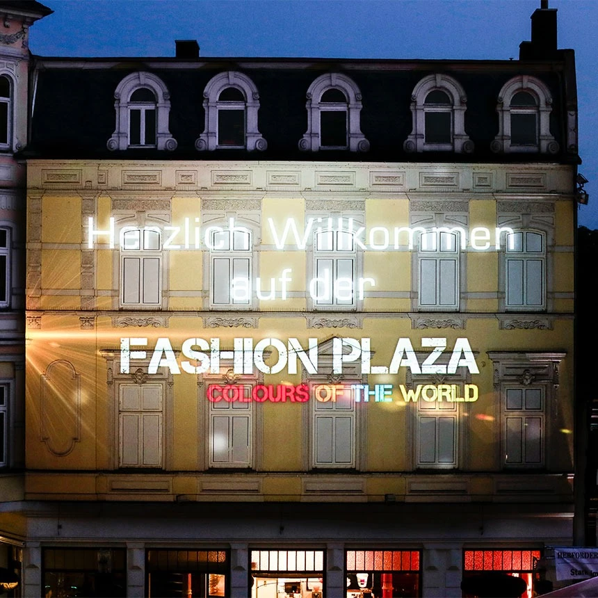 Fassadenprojektion mit Schriftzug Herzlich Willkommen im Corporate Design der Fashion Plaza auf dem Stadtfest in Herford