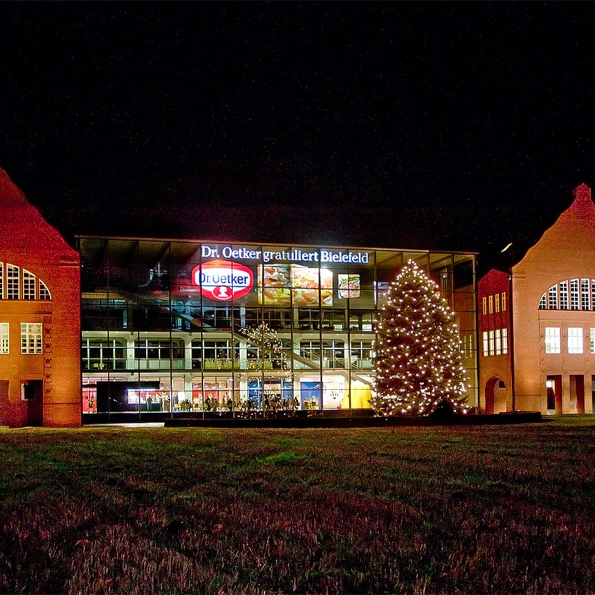 A facade projection onto the glass facade by Dr. Oetker with congratulations on the city of Bielefeld's anniversary
