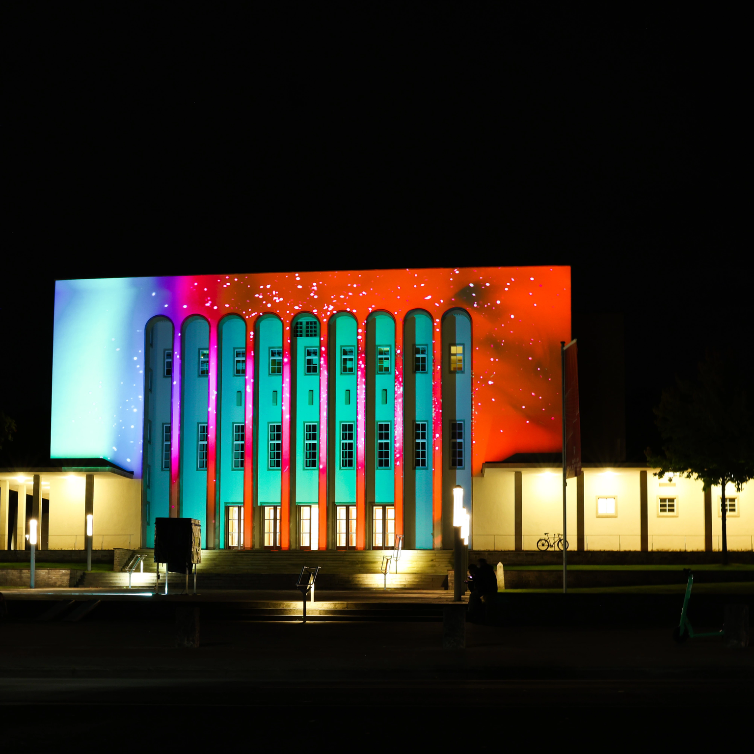 Lichtkunst als Architekturbeleuchtung auf Fassade von Konzerthalle