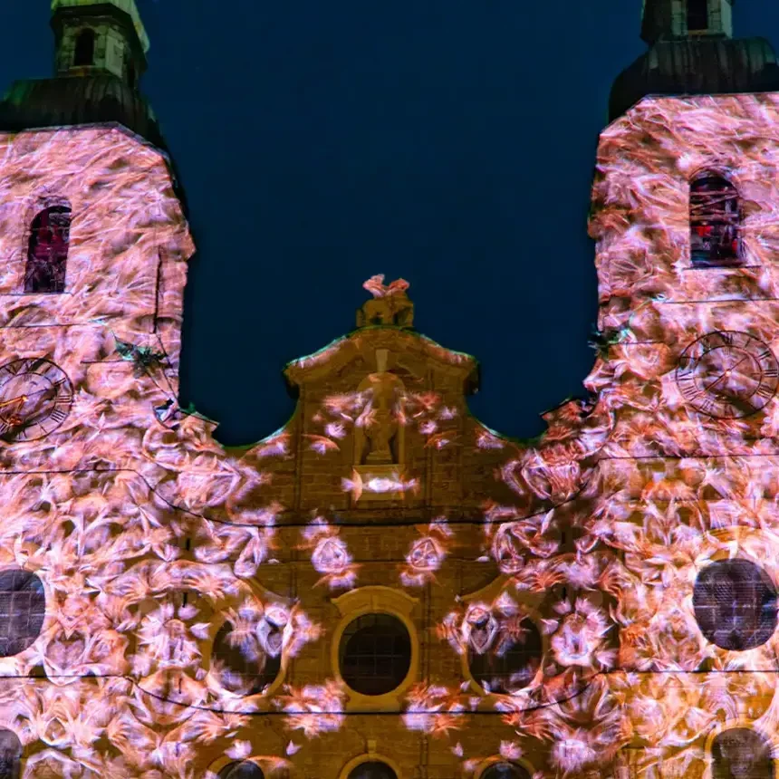Während des Spaziergangs durch Licht in Innsbruck wurde die Kirchenfassade des Doms zu St. Jakob zur Leinwand einer atmosphärischen Videoprojektions-Show unter anderem mit pinken Texturen