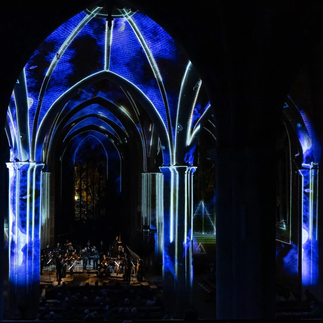 Atmosphärische Visuals in blau und weiß im Innenraum einer Kirche machen ein Konzert des Bremer zu einem immersiven Erlebnis