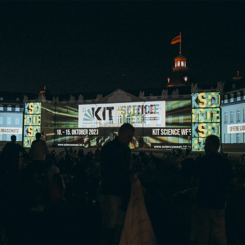 Projectionmapping auf dem Karlsruher Schloss bei den Schlosslichtspiele 2023 – informativer Content-Beitrag des KIT zur Science Week mit mehrfarbigen Infografiken und Textprojektionen über die gesamte Schlossfront bei Nacht