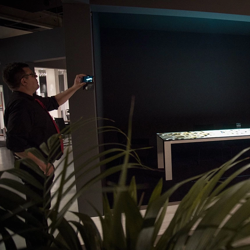 A special exhibit at a furniture exhibition: A three-dimensional projection can be seen on the surface of a dining table, which uses animation to highlight the advantages of the new product