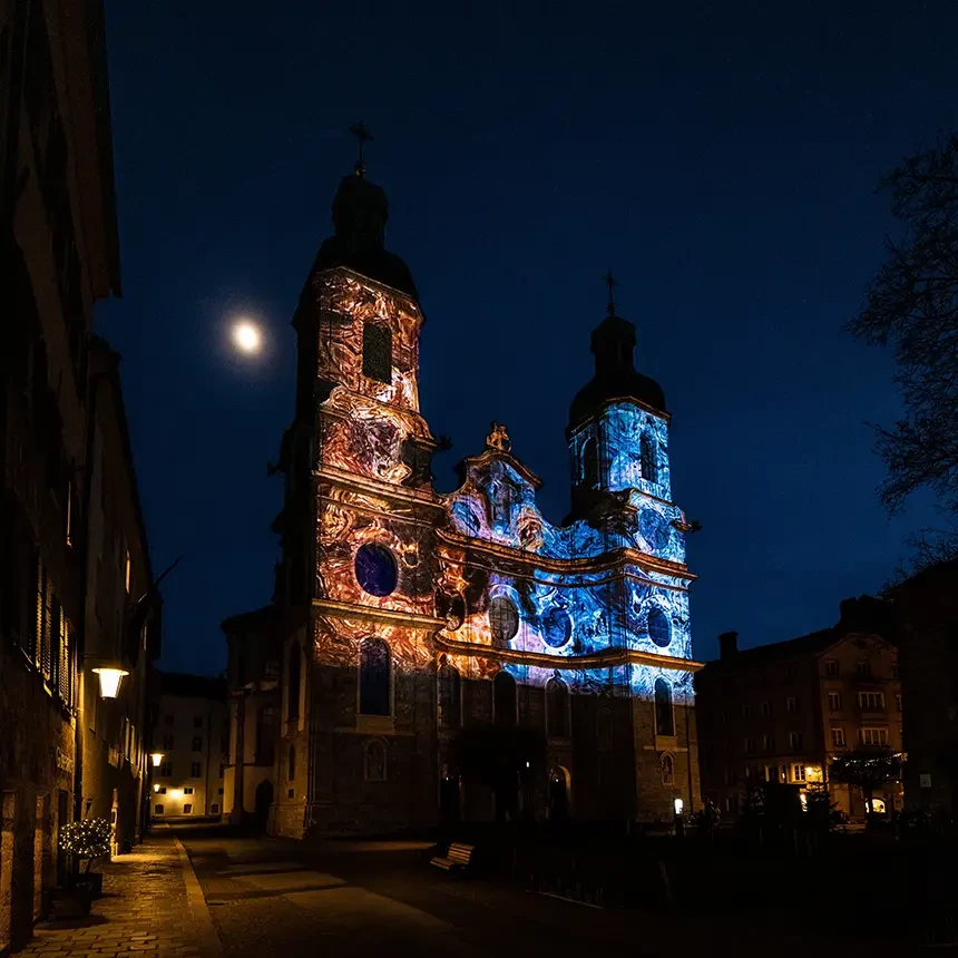 3D Video Mapping inszeniert den Innsbrucker Dom zu St. Jakob während eines Lichterfestivals: Die Elemente Feuer und Wasser legen sich virtuell wie eine zweite Haut auf die Fassade