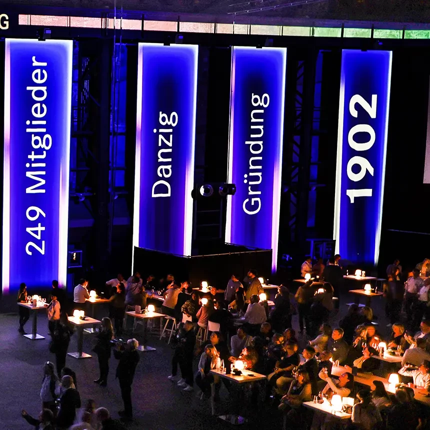 At an anniversary event, the guests watch a projection show that guides them through the company's history with dates