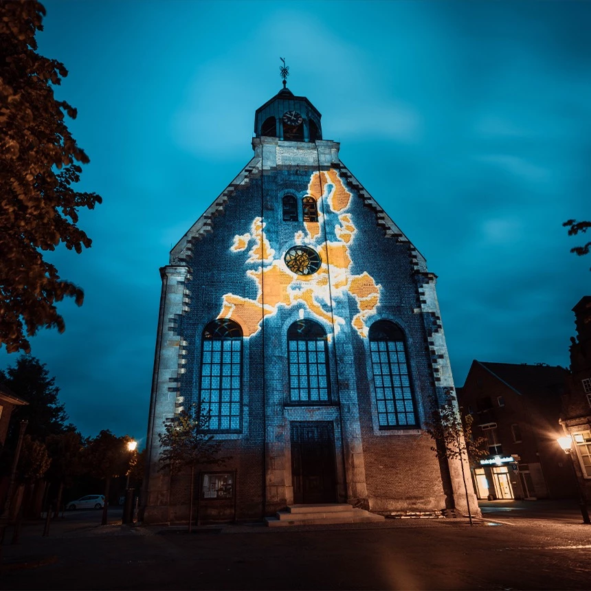 Light installation art map of Europe projected onto church building in Neuenhaus