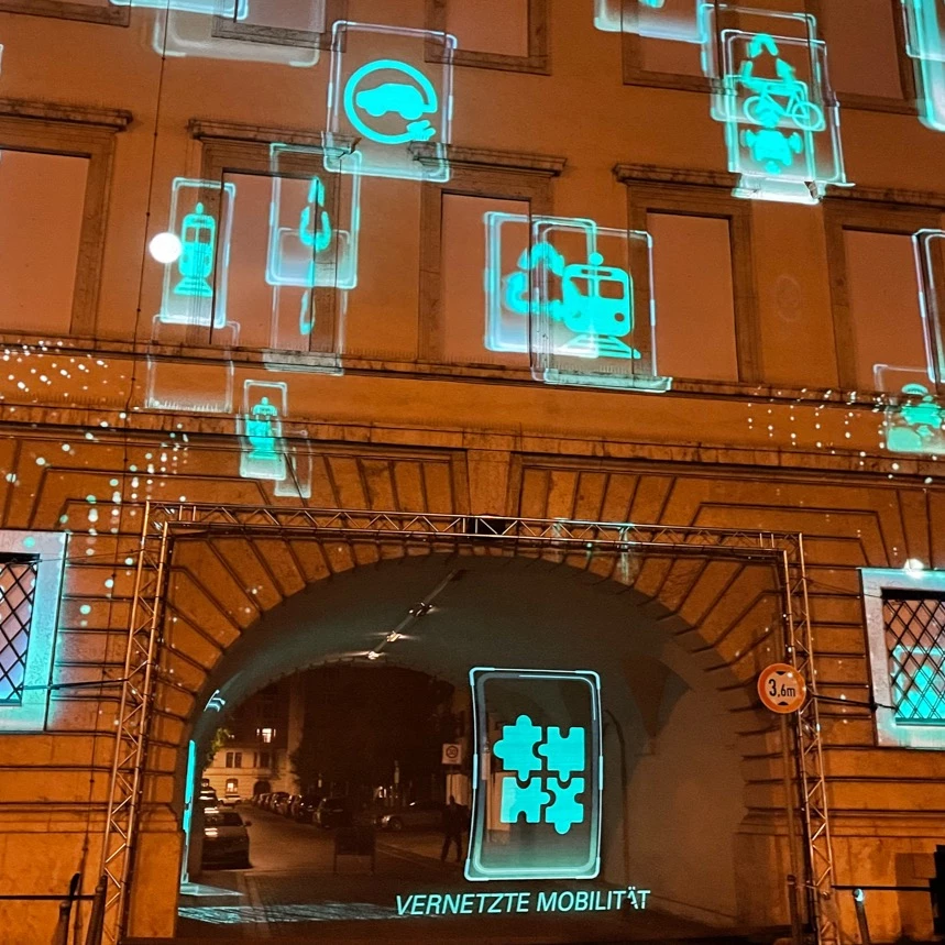 Icons on the subject of future mobility are projected onto buildings and seemingly into the air