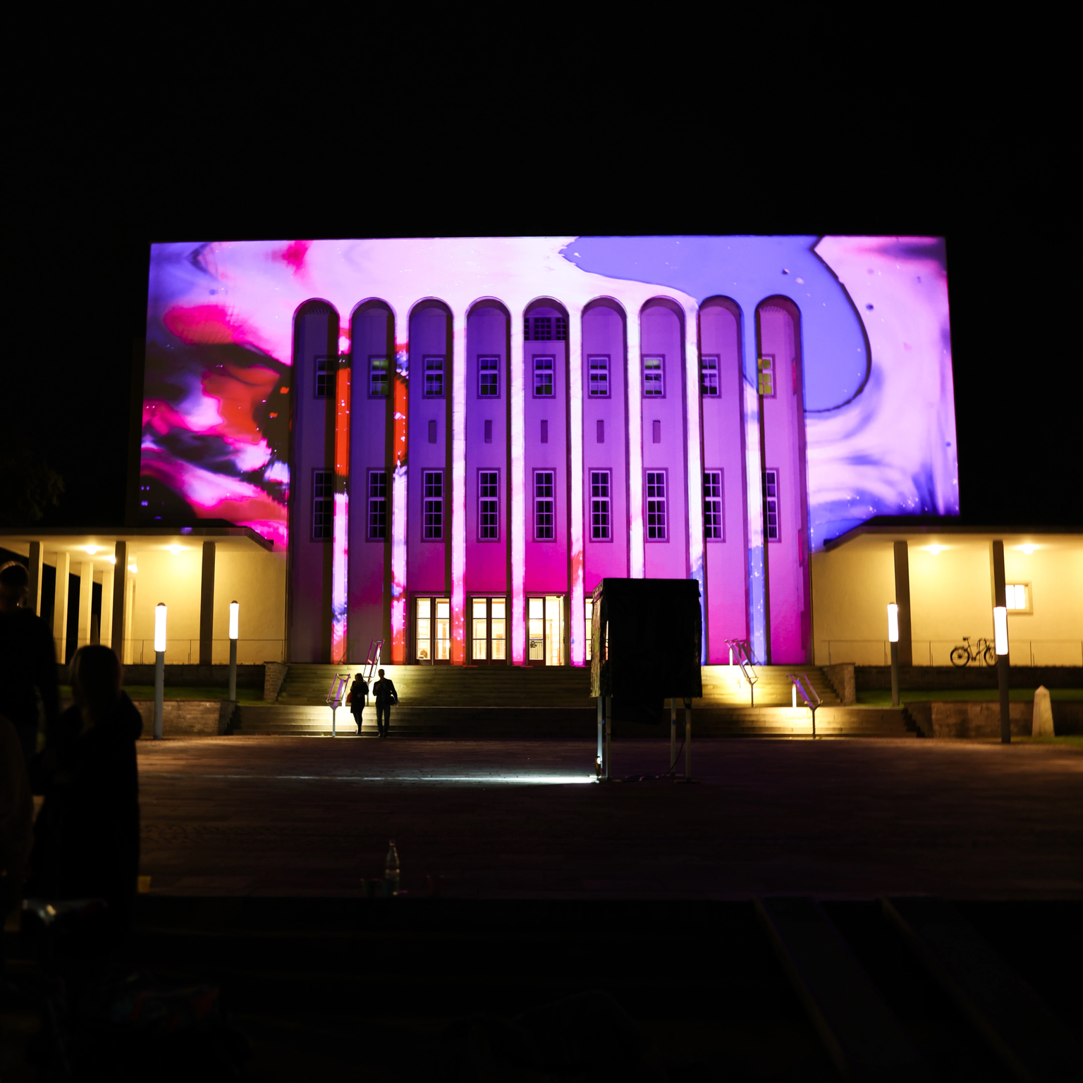 Lichtinstallation auf Konzertbau Rudolf-Oetker-Halle: Projektion zeigt organische Strukturen in pink und lila