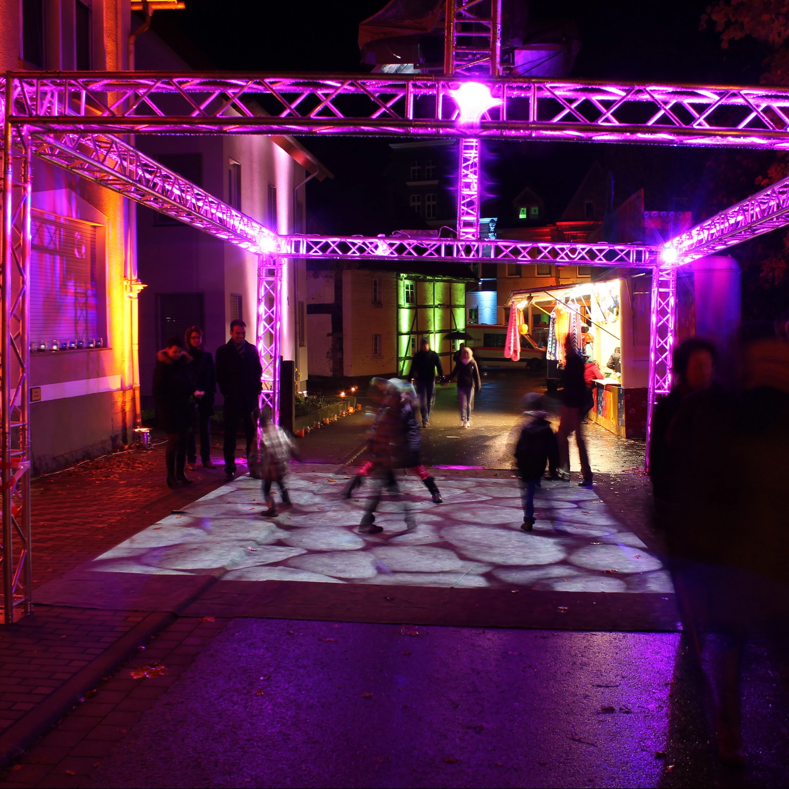 Eine interaktive Bodenprojektion als Hightlight bei einem Stadtfest: Kinder in Aktion mit der virtuellen Welt sind auf der Projektionsfläche zu sehen